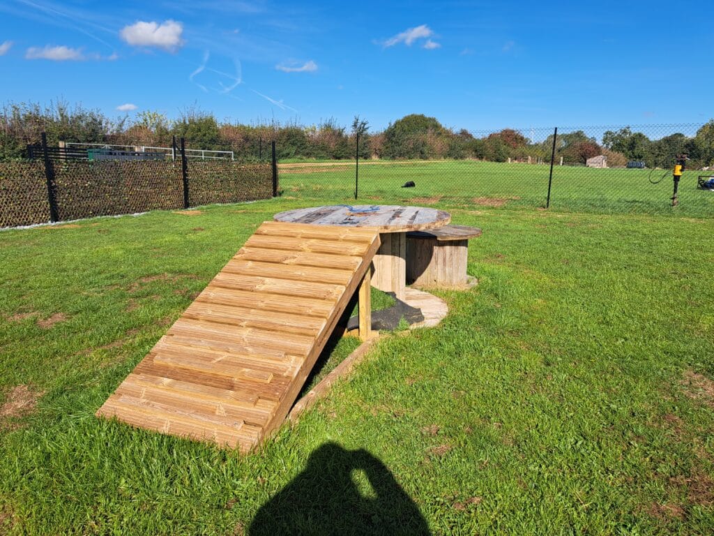 Wooden agility ramps in the secure dog field at Foxholes Farm Dog Park
